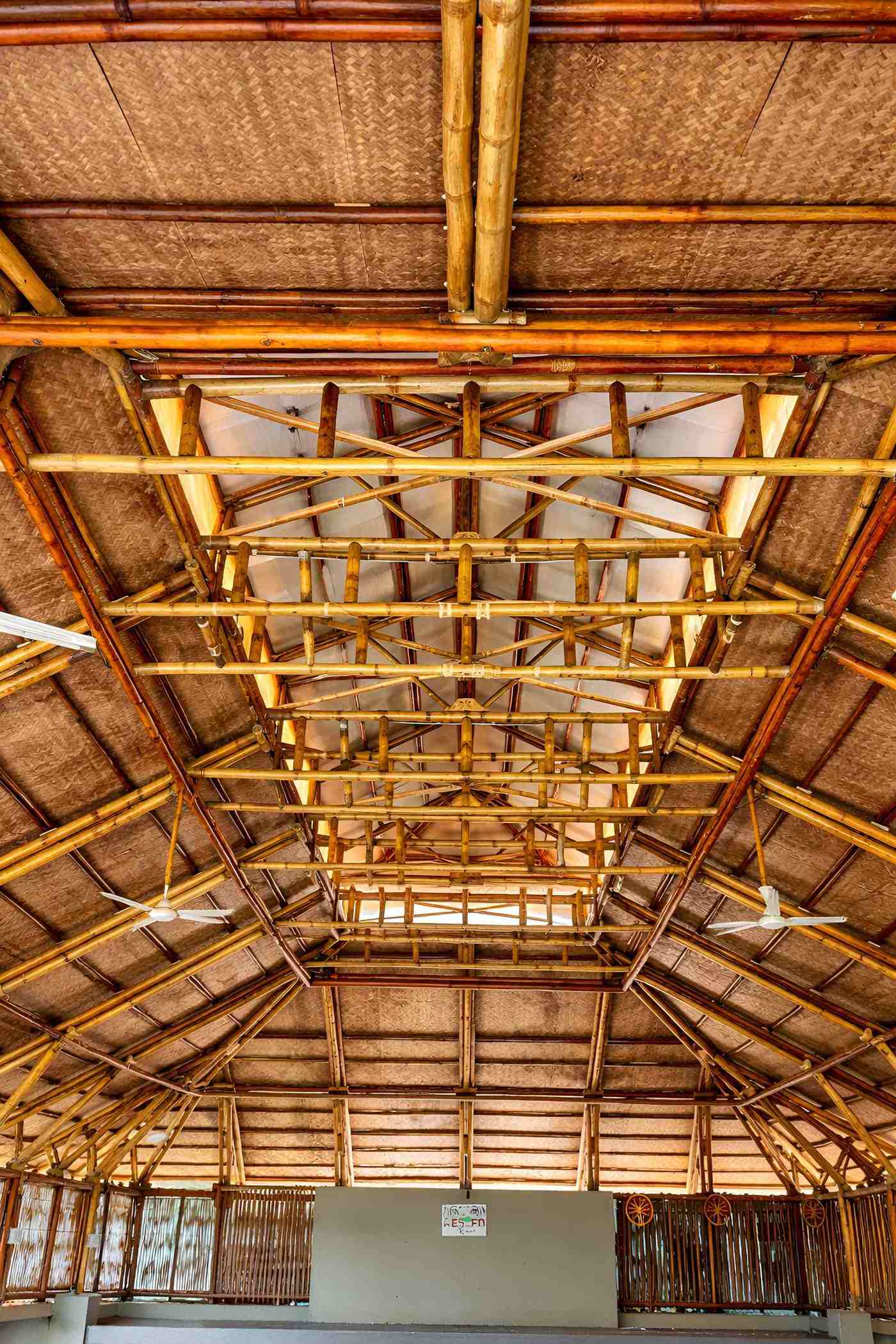 Interior bamboo ceiling — warm-lit truss detail with pendant lighting