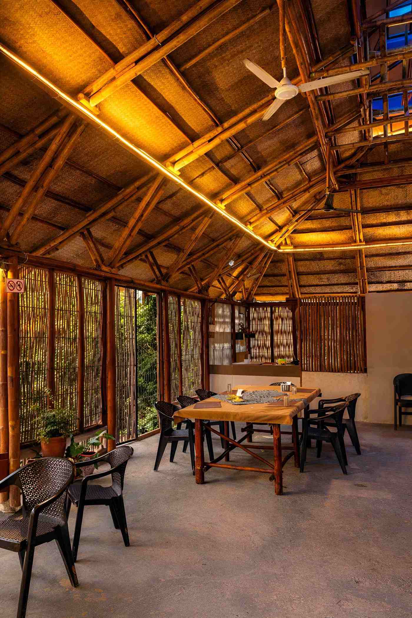 Interior view looking toward the open sides — dining layout with forest view