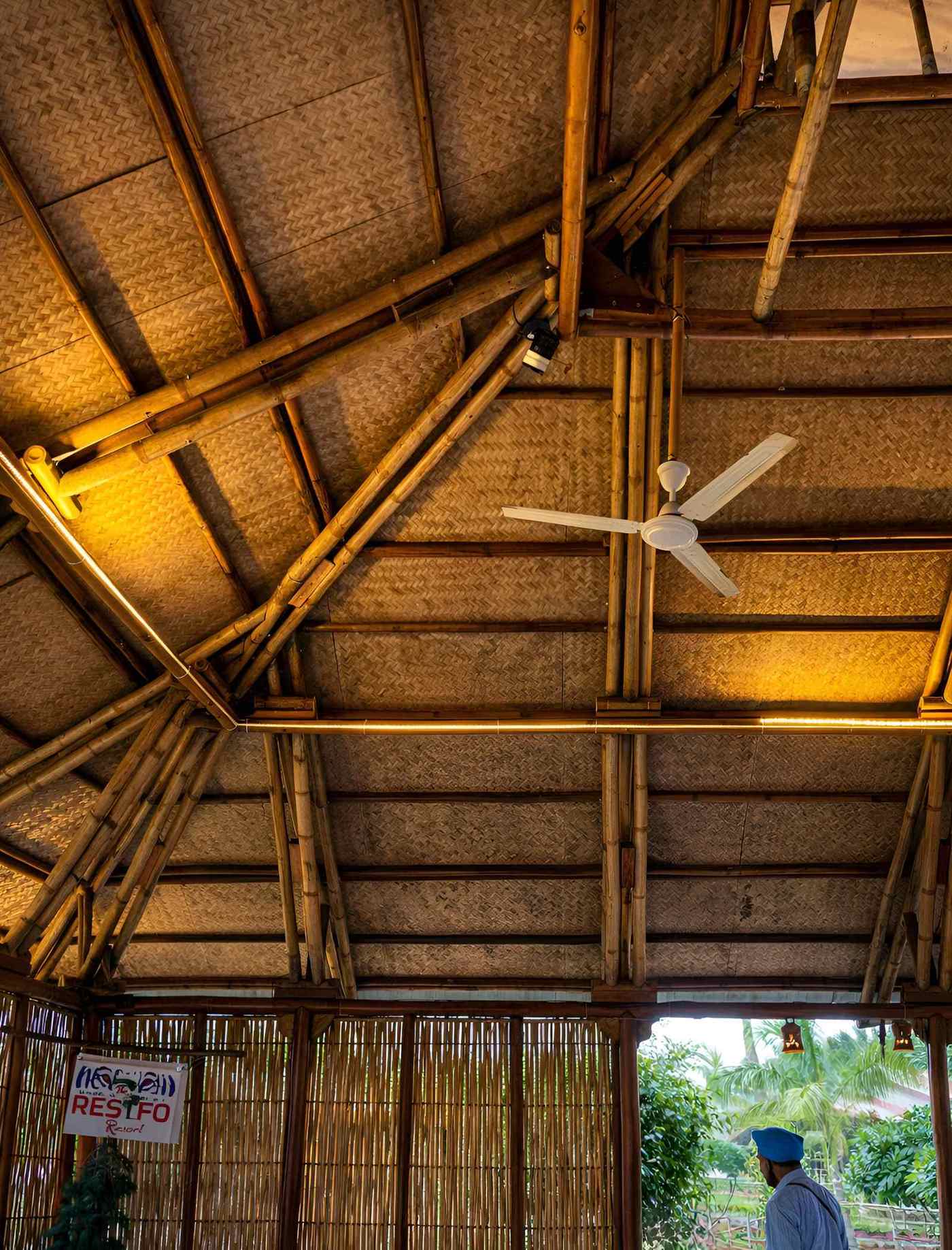 Interior — fan and bamboo ceiling at night with warm ambient light