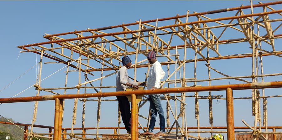 Bamboo columns being positioned and plumbed