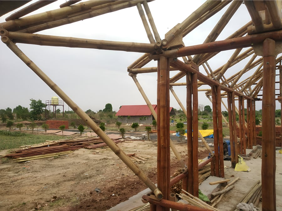 Bamboo truss assembly being positioned on the structure